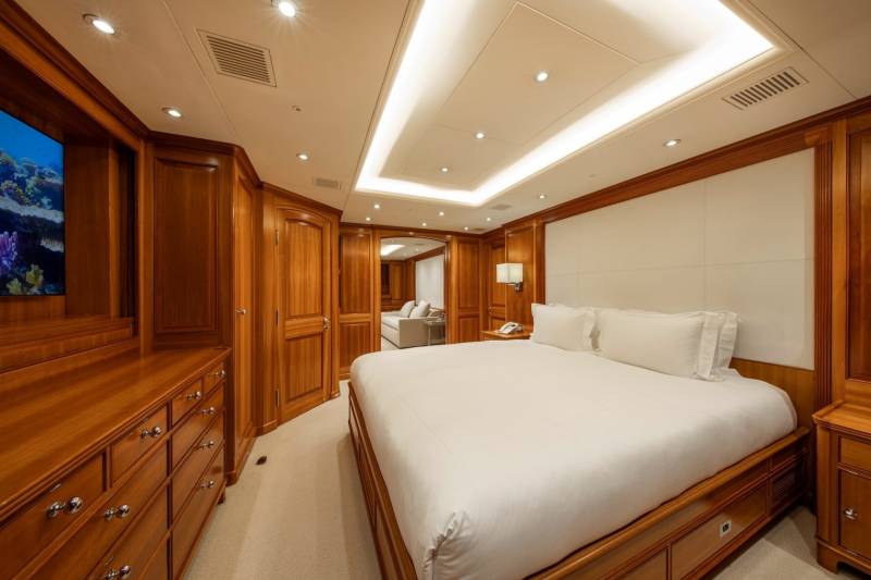Luxurious wood paneling and plush white bedding create a serene sanctuary aboard this elegant yacht.