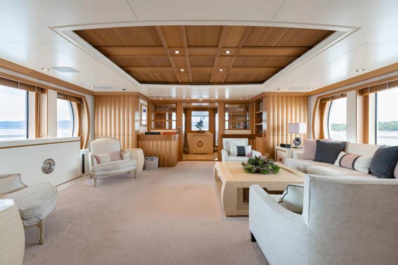Luxurious yacht interiors offer a serene retreat with plush seating, warm wood accents, and expansive windows overlooking the sea.