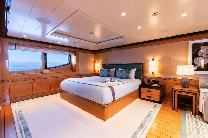 Luxurious yacht master suite offers a serene retreat with ocean views and elegant wood finishes.