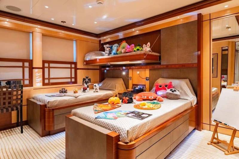 Bunk beds adorned with plush toys create a playful and cozy retreat in this luxurious yacht cabin.