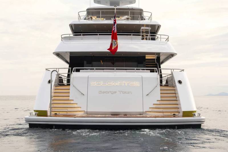 The luxurious yacht "Solemates" glides through calm waters, its name illuminated on the stern.