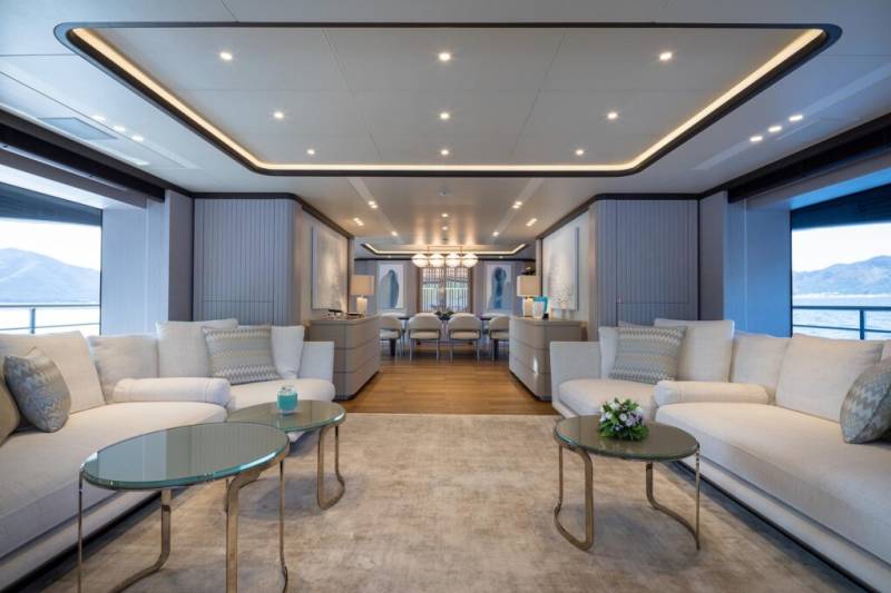 Luxurious yacht interiors offer a serene ambiance with plush seating and elegant dining spaces overlooking the ocean.
