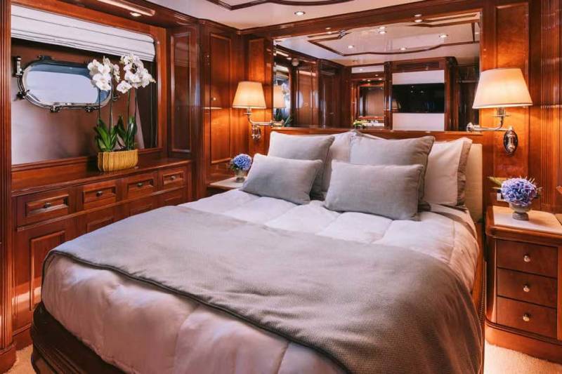 Luxurious wood paneling and a plush bed create a serene retreat aboard this elegant yacht.