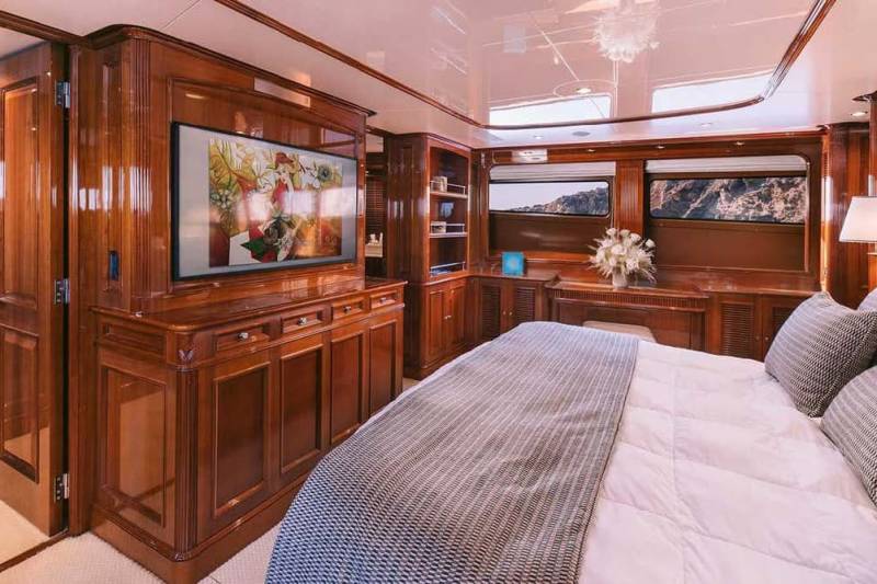 Luxurious wood paneling and a large television create a cozy and elegant master suite aboard this yacht.