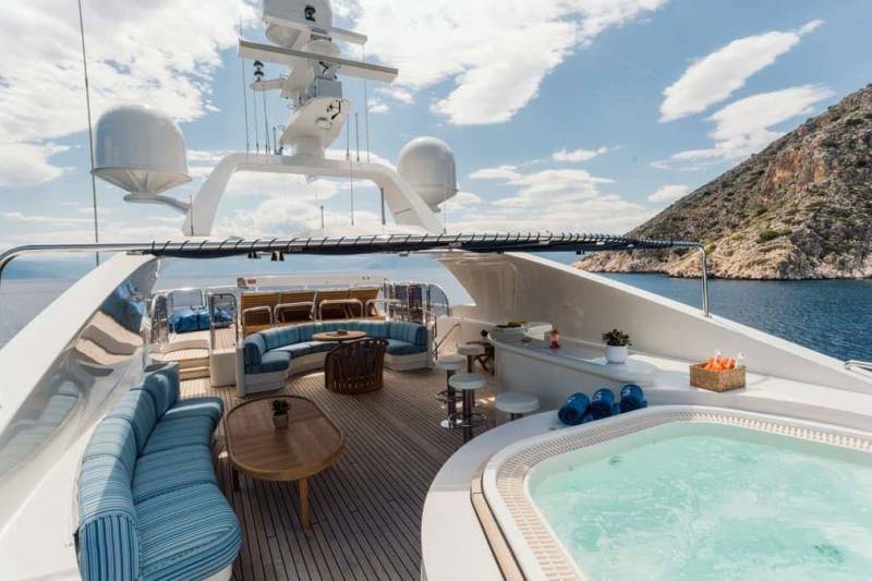 Relax in the jacuzzi on the deck of this luxurious yacht, surrounded by stunning coastal scenery.