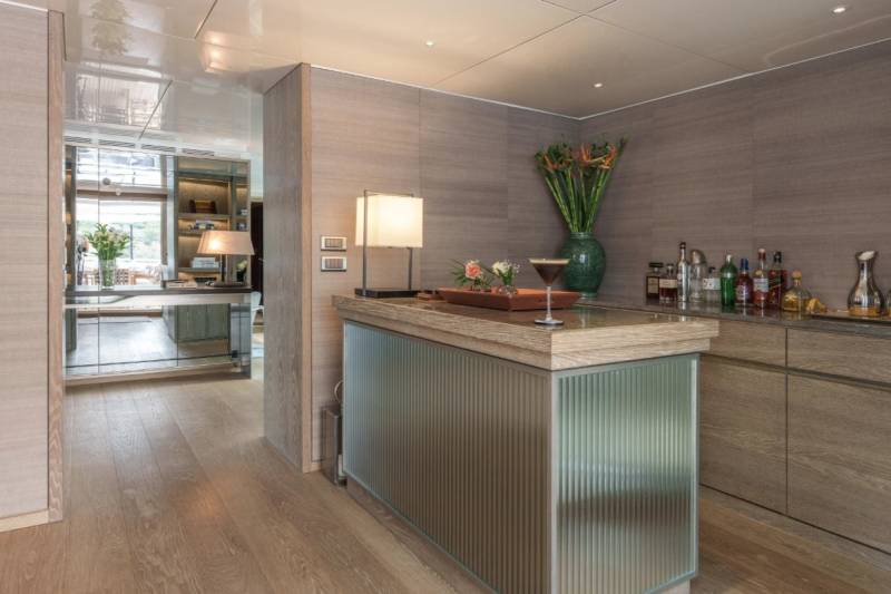 A modern bar area with a sleek counter, sophisticated glassware, and a vibrant floral arrangement sets a luxurious tone.