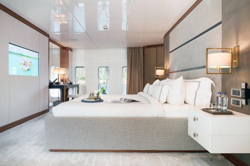 Luxurious yacht cabin features a plush bed, modern entertainment system, and stunning ocean views.