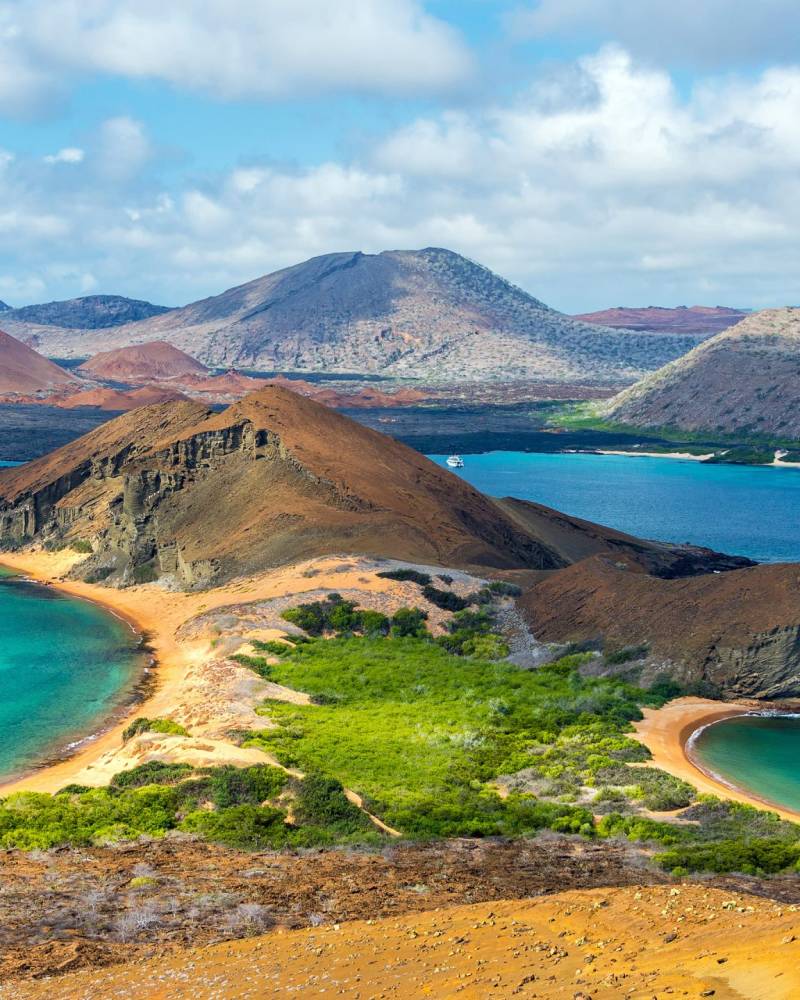 The striking volcanic landscape of Bartolome Island in the Galapagos Islands features turquoise bays and dramatic rock formations.