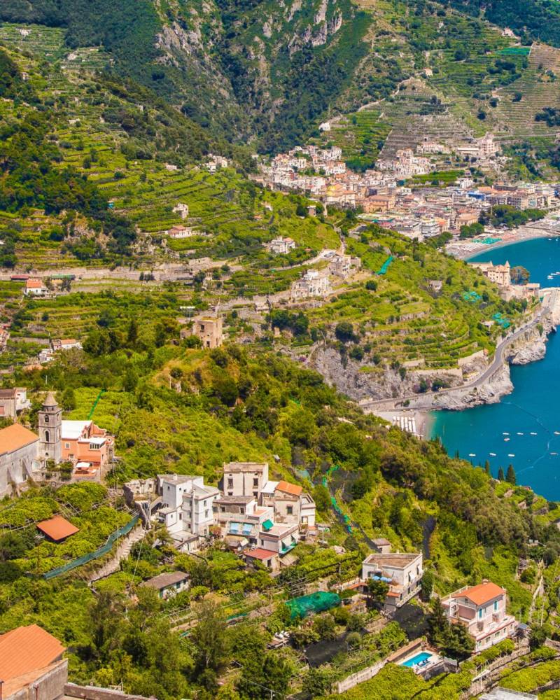 Terraced hillsides cascade down to the sparkling blue waters of the Amalfi Coast, dotted with picturesque villages.