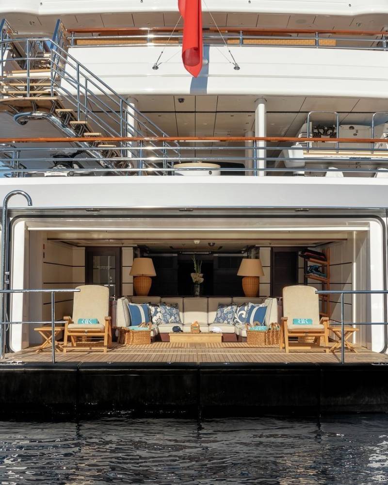 The luxurious aft deck of a superyacht offers a serene lounge area with comfortable seating and stunning ocean views.