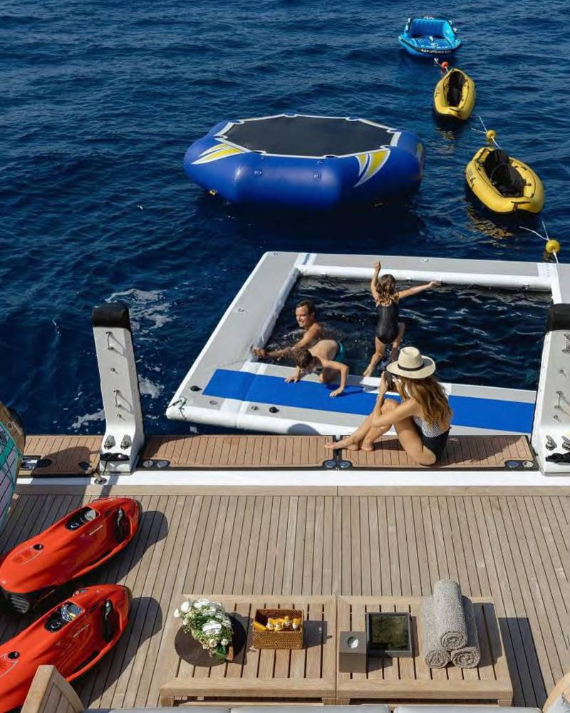 A luxurious yacht deck offers a refreshing escape with an inflatable pool and various water toys for ultimate ocean enjoyment.