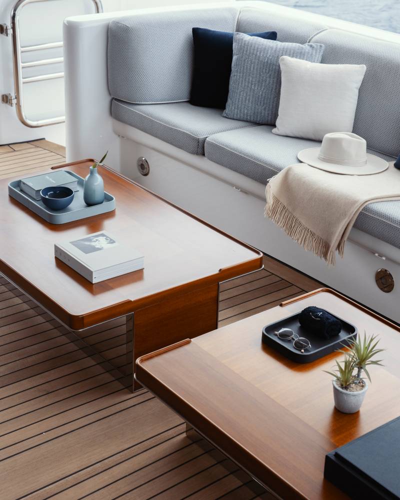 Relax on the yacht's deck with a book, a stylish hat, and a refreshing drink as the ocean breeze washes over you.