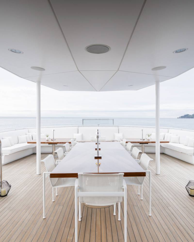 Luxurious outdoor dining awaits on this yacht's deck, complete with elegant seating and stunning ocean views.