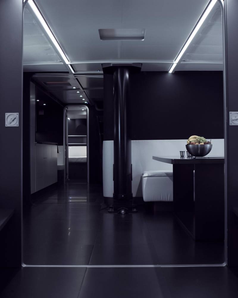 Sleek, modern interiors with white beds and a fruit bowl on a dark table create a luxurious ambiance.