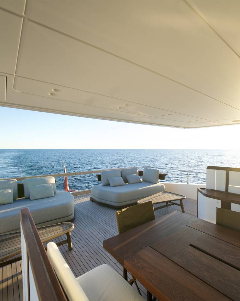 Relax on the luxurious deck of a yacht as the sun sets over the tranquil blue ocean.