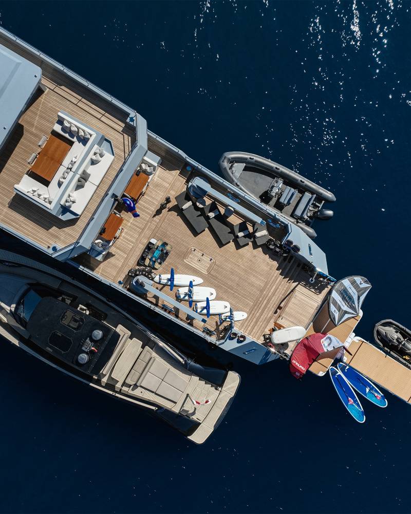 A large boat with various equipment and gear visible on its deck, surrounded by deep blue waters.