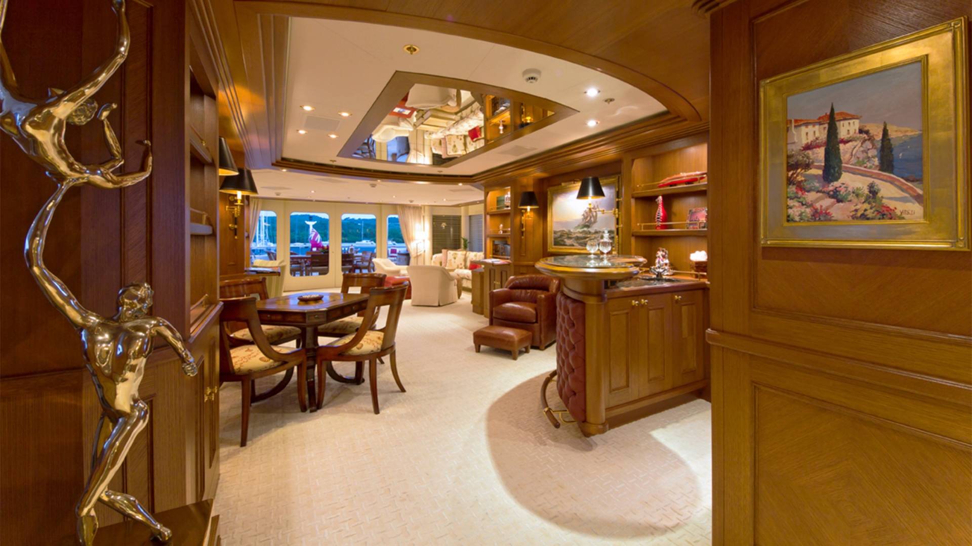Gilded sculptures and rich wood paneling adorn this luxurious yacht interior, offering a glimpse of opulent onboard living.