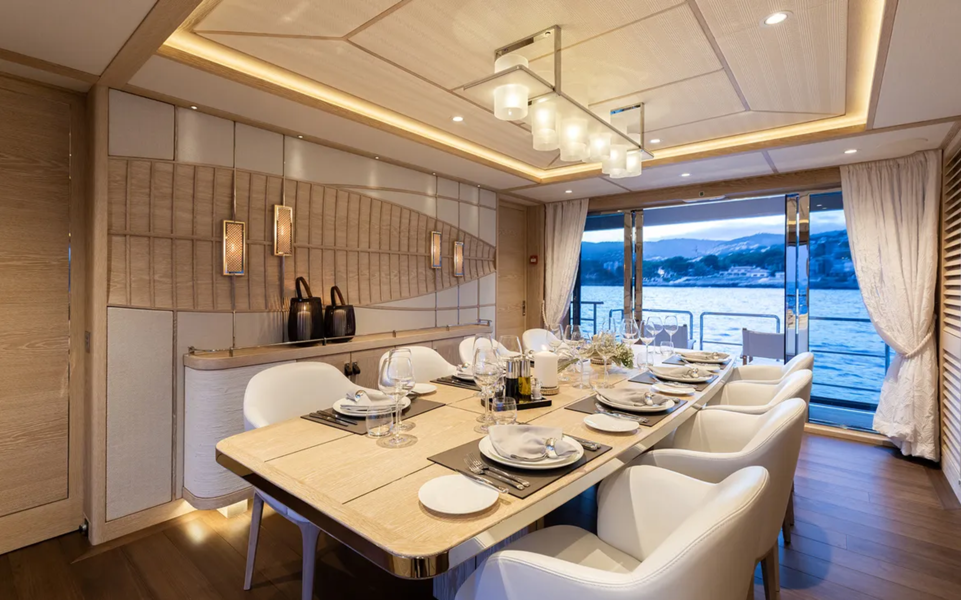 An elegant dining room on a yacht offers a sophisticated setting for a meal with a stunning view of the sea.