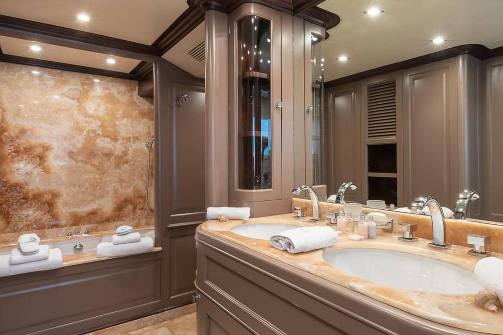 Luxurious marble countertops and a deep soaking tub create an opulent retreat in this yacht's master bathroom.