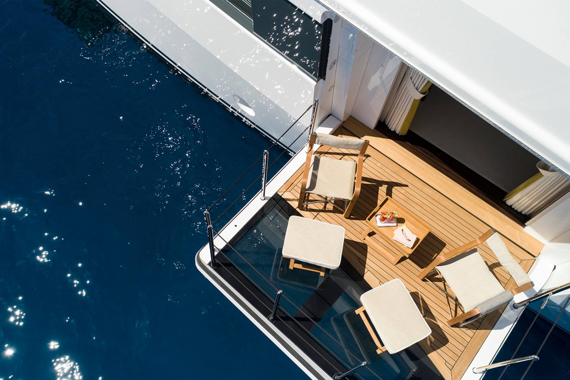 Relax on the teak deck of this luxurious yacht, enjoying drinks and the sparkling blue ocean.
