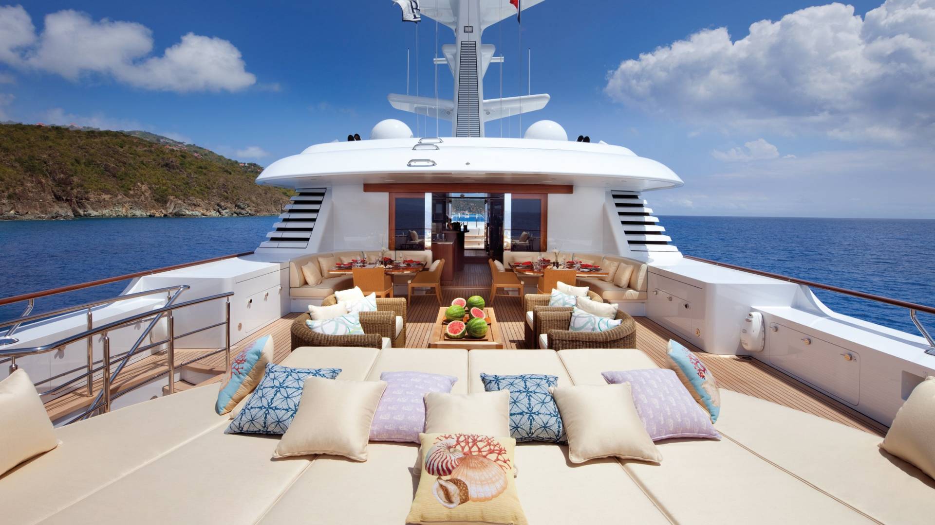Luxurious outdoor seating and dining areas on a yacht offer a perfect setting for enjoying the tropical ocean breeze.