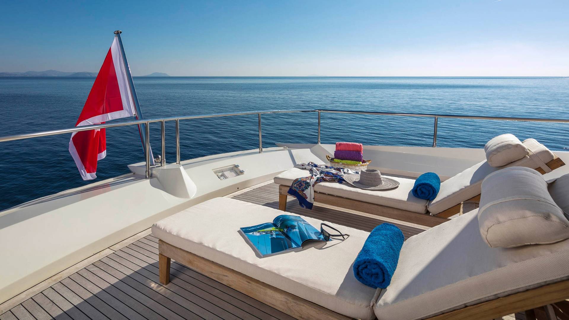 Relax on the deck of a luxurious yacht with the endless blue ocean stretching out before you.