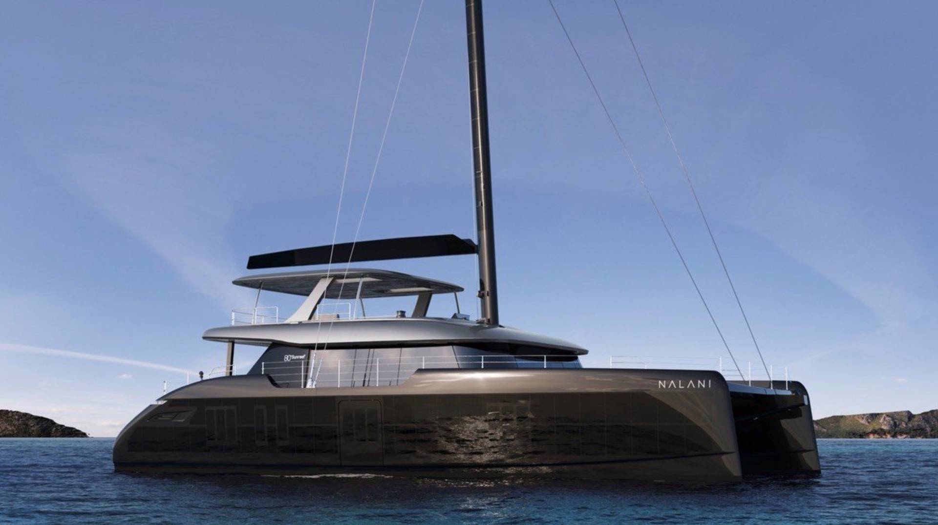 Sleek black catamaran Nalani glides through calm blue waters under a clear sky.