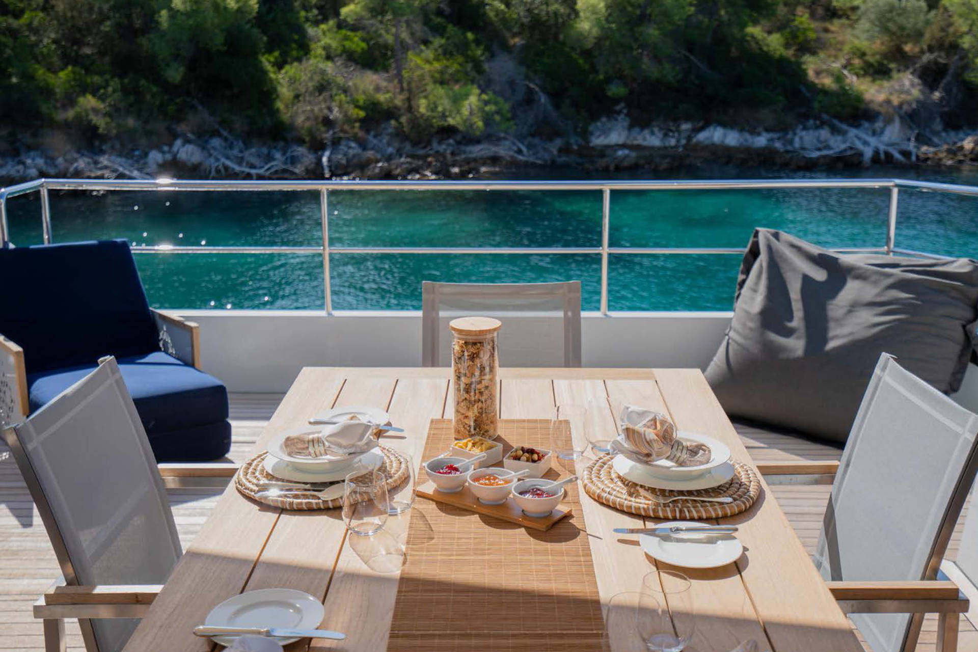 Enjoy a serene breakfast on deck overlooking the crystal-clear turquoise waters and lush green coastline.