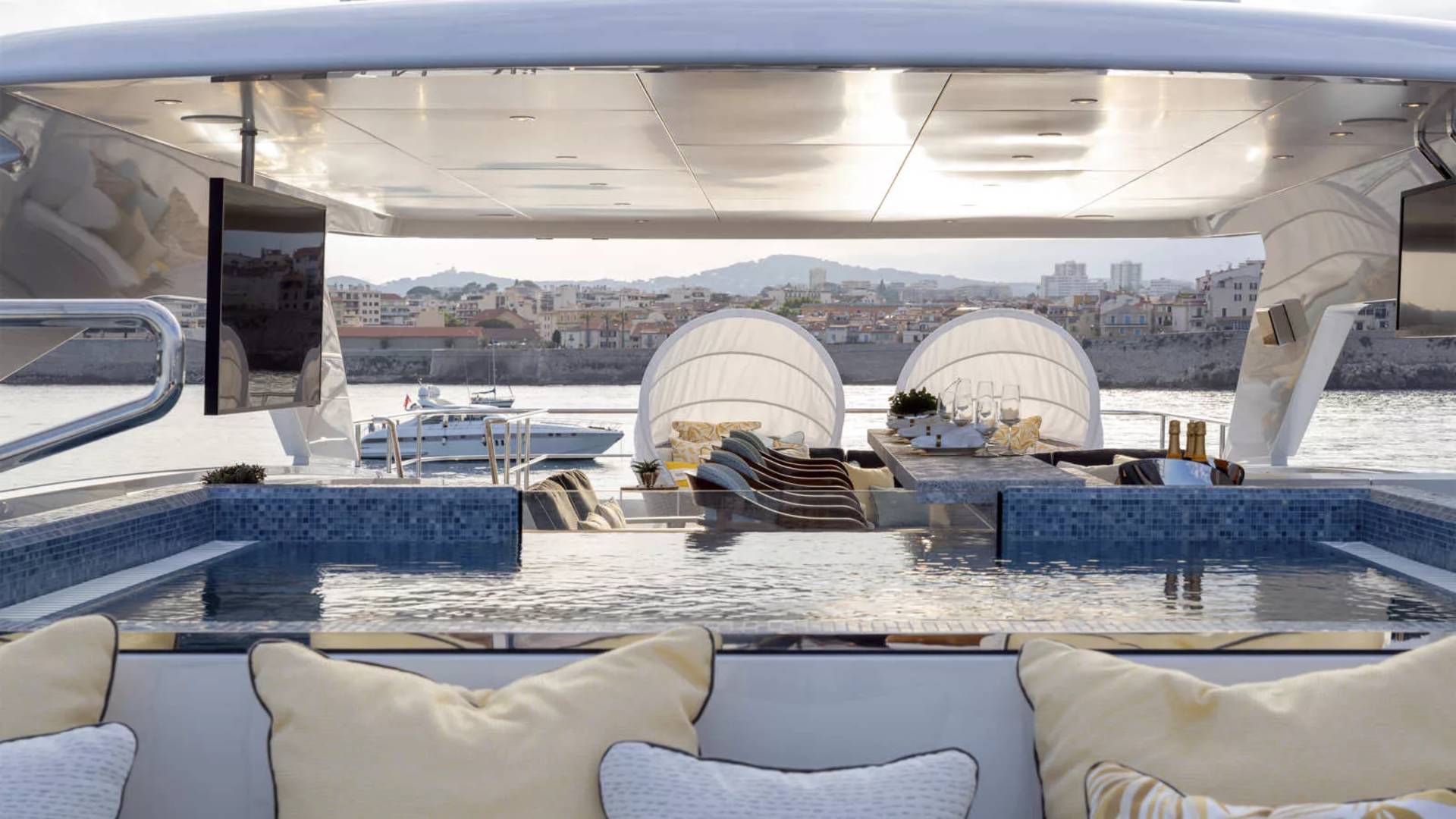 Relax in the infinity pool of this luxurious yacht, with a picturesque coastal town as your backdrop.