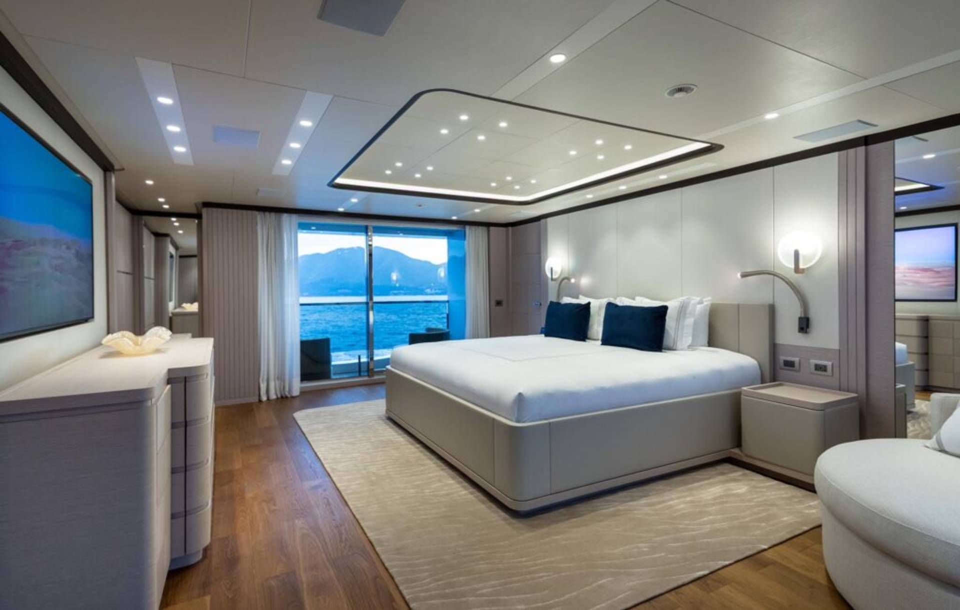 Luxurious yacht bedroom offers stunning ocean views and modern comfort with a king-sized bed and elegant decor.