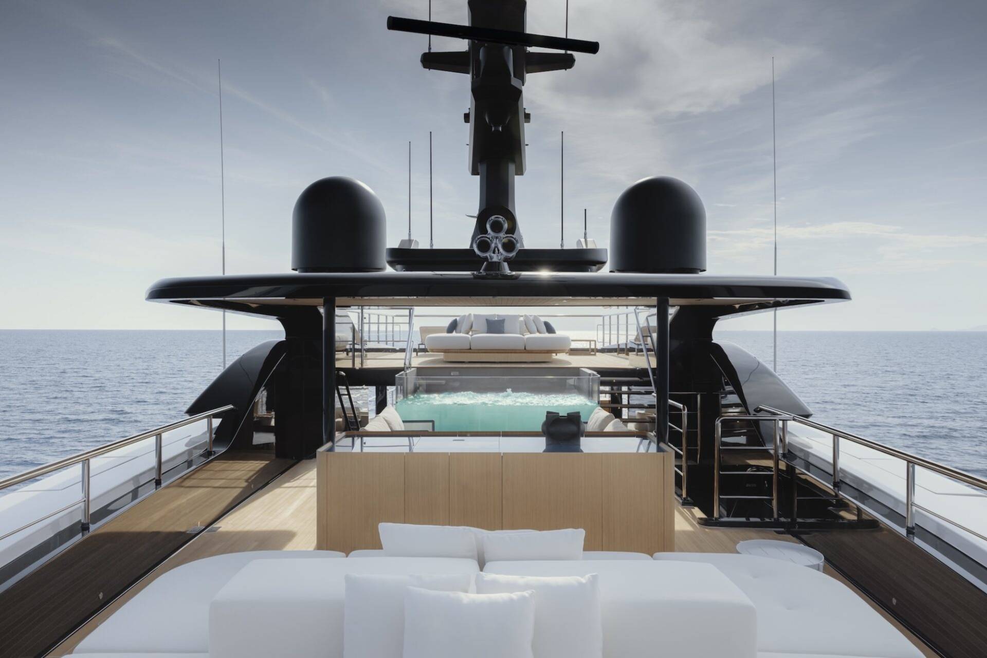 Luxurious yacht deck features a pristine pool and plush seating overlooking the tranquil ocean.