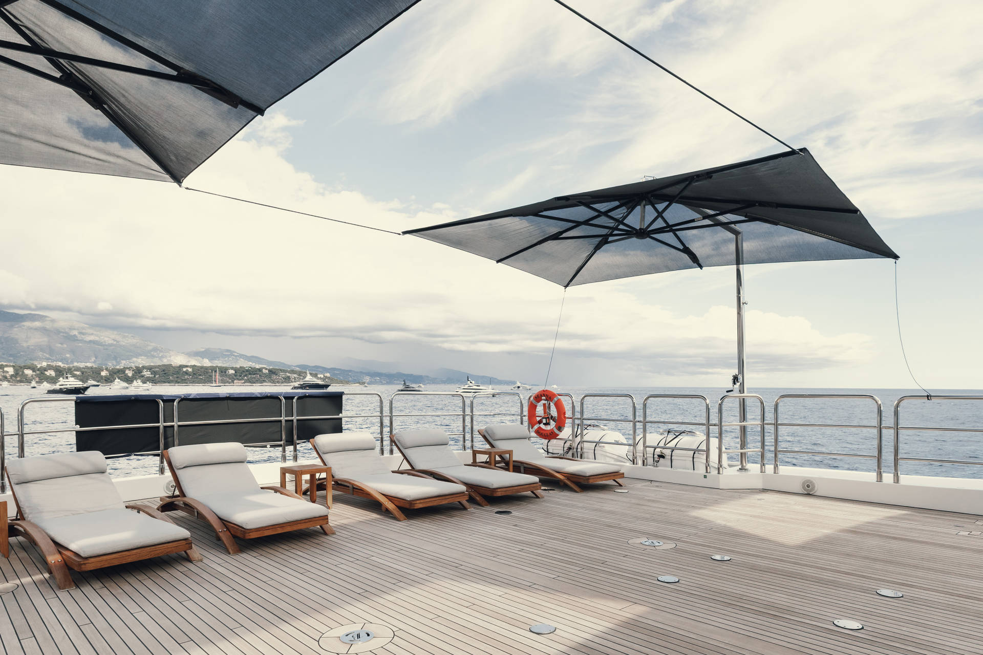 Relax on the spacious deck of a luxury yacht, surrounded by the serene beauty of the Mediterranean coast.