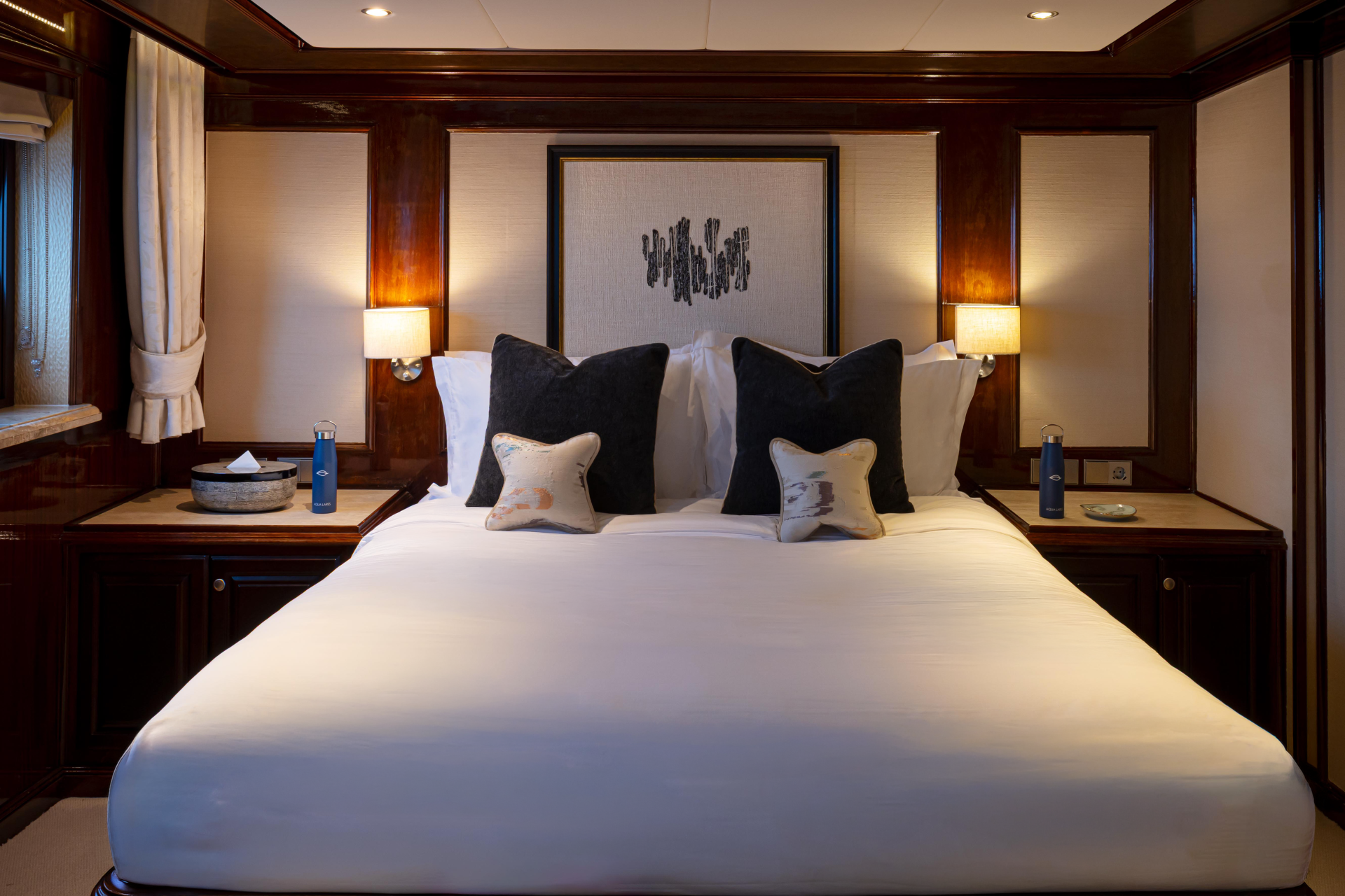A cozy and elegant bedroom with a large, plush bed, dark wood furnishings, and decorative lighting, creating a warm and inviting atmosphere.