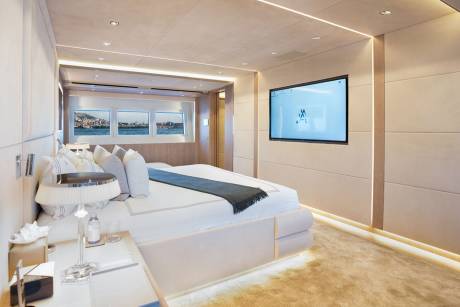 Luxurious yacht interiors offer a serene escape with plush bedding, elegant lighting, and panoramic views of coastal cities.