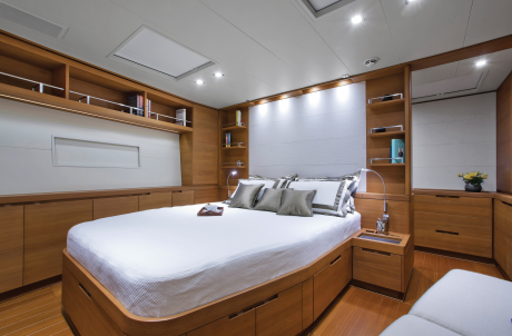 Luxurious wooden cabinetry and a plush bed create a serene master suite on this elegant yacht.