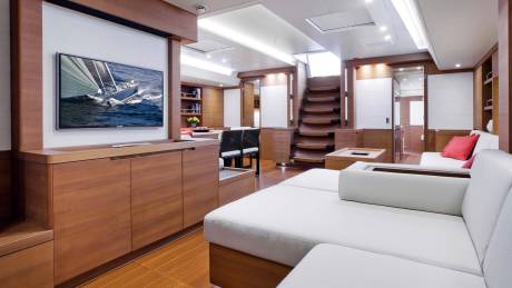 Luxurious yacht interiors feature warm wood finishes, a large television, and comfortable seating areas.