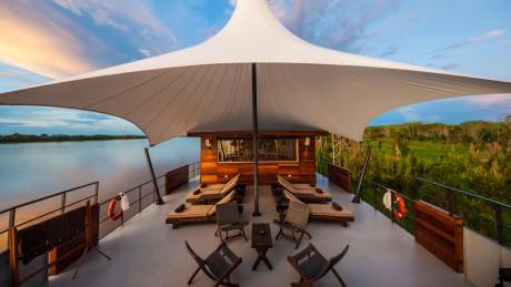 Relax on the deck of this riverboat, surrounded by lush greenery and the tranquil waters of the Amazon.