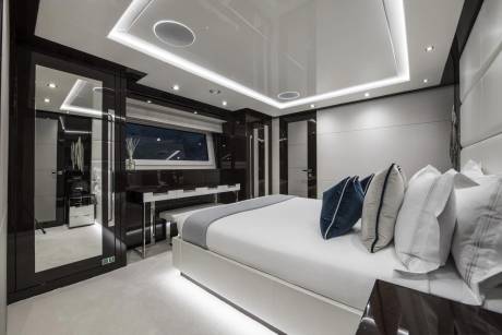 Luxurious modern bedroom with sleek black cabinetry, a plush white bed, and ambient lighting creates a serene retreat.