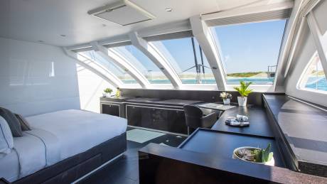 Luxurious yacht cabin offers a serene retreat with expansive windows framing a breathtaking ocean vista.