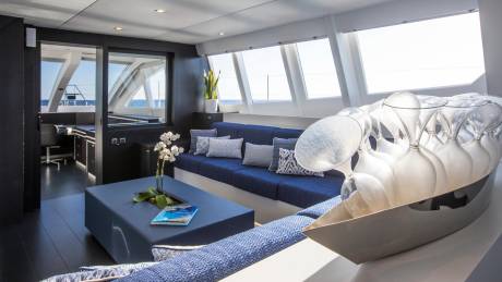 Luxurious yacht interiors offer stunning ocean views through expansive windows, complemented by plush seating and elegant glassware.