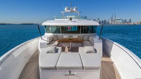 Relax on the spacious deck of this luxurious yacht, complete with comfortable seating and a dining area, as the cityscape glides by.
