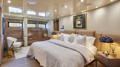 Luxurious bedroom with a Chanel art piece and a plush bed offers a serene escape with scenic views.