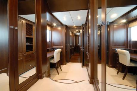 Luxurious dark wood paneling and plush carpeting create an elegant and inviting atmosphere in this yacht's interior.
