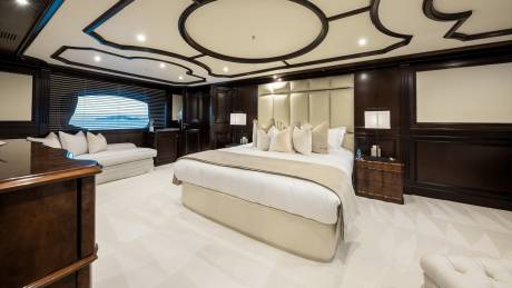 Luxurious dark wood paneling and a plush bed create an opulent sanctuary on this elegant yacht.