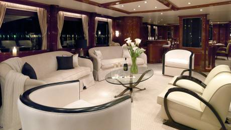Luxurious yacht interiors offer a sophisticated retreat with plush seating and elegant decor overlooking a nighttime cityscape.
