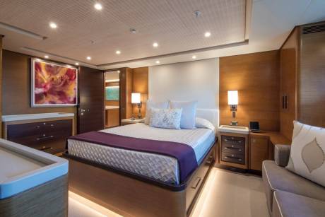Luxurious yacht accommodations feature a plush bed, modern art, and warm wood accents for ultimate comfort at sea.