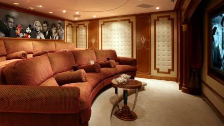 This luxurious home theater features plush seating, classic Hollywood art, and a large screen for an immersive cinematic experience.