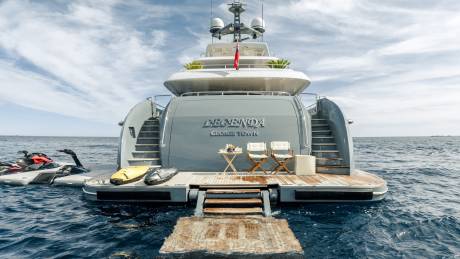Two jet skis and a yellow sea scooter are docked at the stern of the luxurious yacht "LEGEND" in George Town.