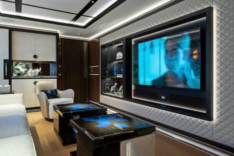 Luxurious yacht interiors feature a modern entertainment area with a large screen television and stylish coffee tables.