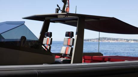 Sleek, modern seating with bold red accents awaits passengers on this luxurious yacht cruising the azure waters.